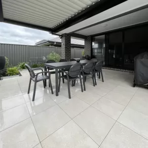 A louvered pergola adds an extra dining area set in a garden area in this home in Oran Park